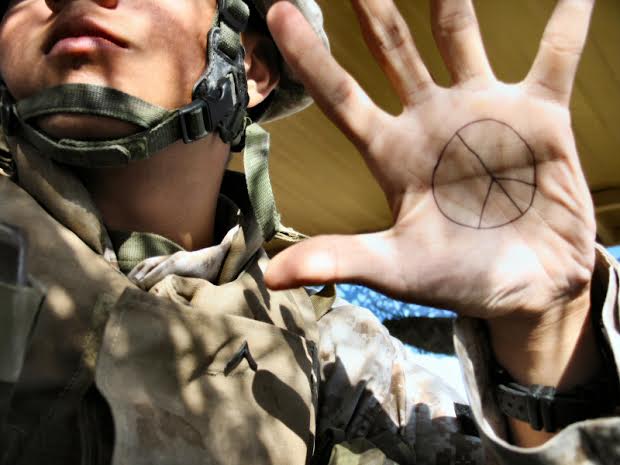 Soldier with peace symbol written on his hand